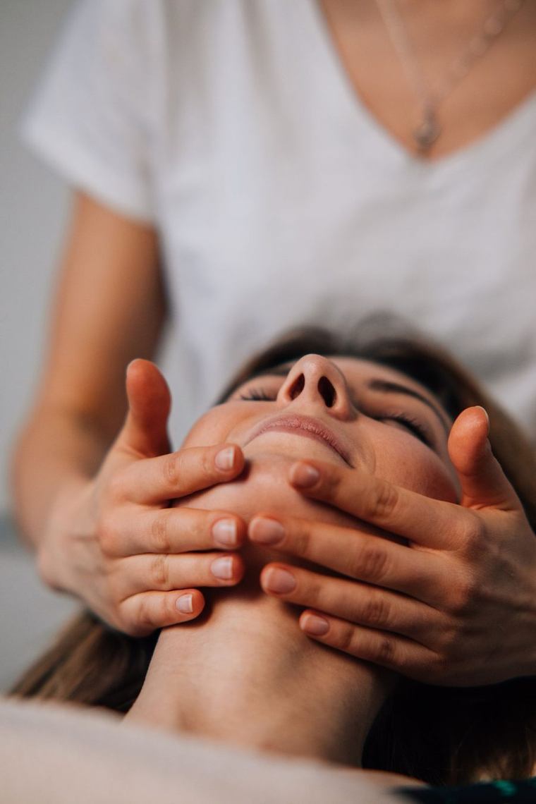 Gezichtsmassage bij een ontspannen cliënt