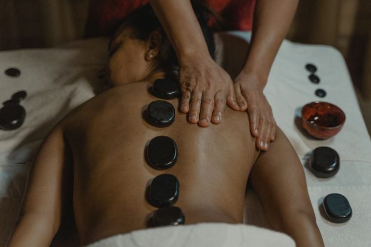 Hot stone massage met verwarmde basaltstenen op de rug