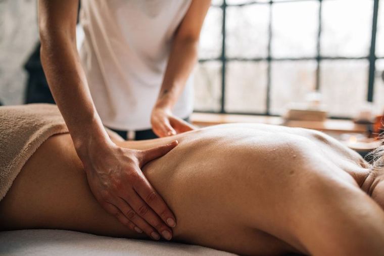 Lange, vloeiende massagebewegingen over de rug