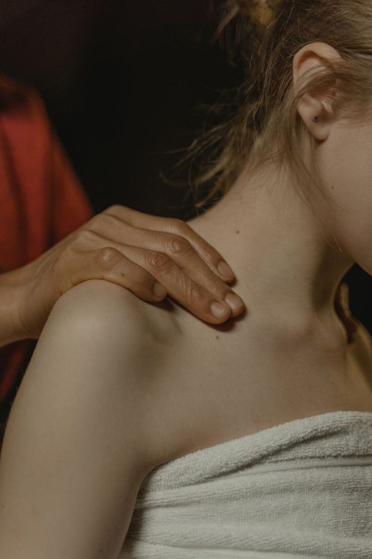 Masseur die de nek en schouders van een cliënt masseert