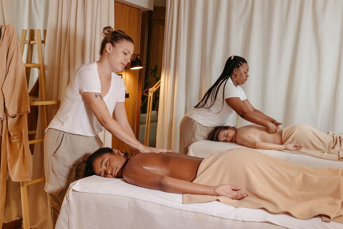 Twee masseurs aan het werk in de warme behandelruimte van Marjaan Wellness